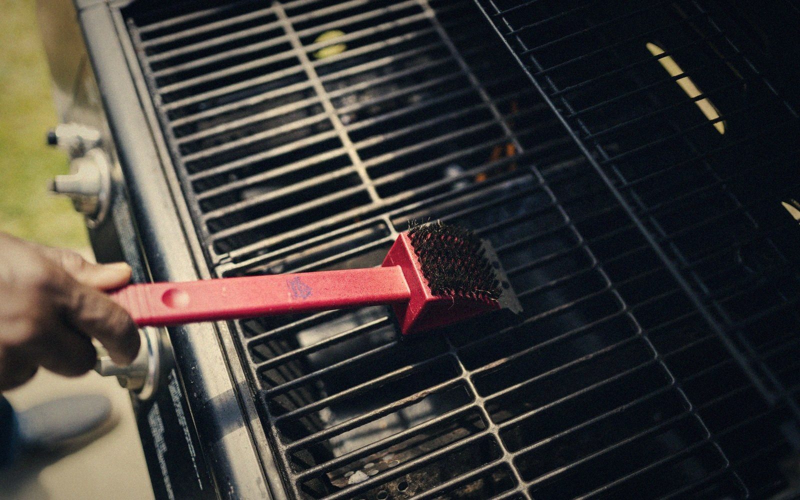 A wire brush on a hot grate, smoke rising